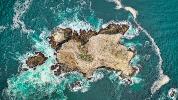 Beautiful overhead aerial shot of coral reefs in the middle of the ocean with amazing ocean waves