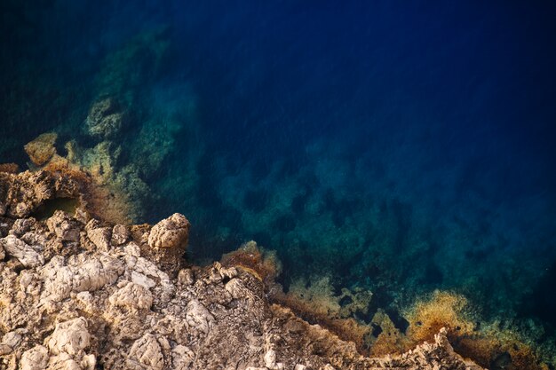 Beautiful overhead shot of rocky cliffs of the sea on a sunny day