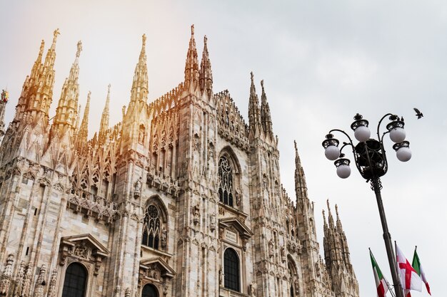 Beautiful Panoramic view of Duomo square in Milan with big street lamp. Italy.