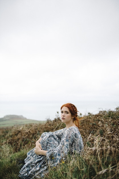 Beautiful picture of a ginger female with a pure white skin in an attractive light blue gown