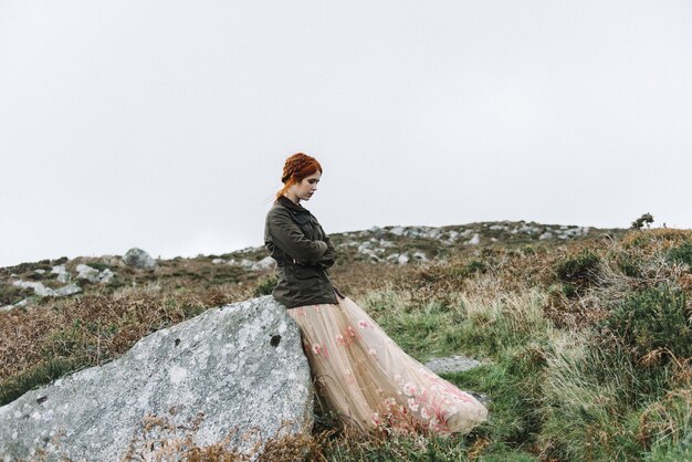 Beautiful picture of a ginger female with a pure white skin in an attractive light pink gown