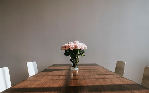 テーブルの上の花瓶に美しいピンクのバラ