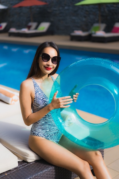 Beautiful portrait asian woman relax happy smile around outdoor swimming pool