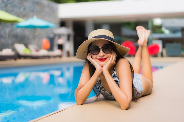 아름 다운 초상화 아시아 여자 야외 수영장 주위에 행복 한 미소를 휴식