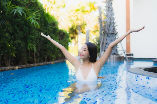 Beautiful portrait young asian woman happy smile relax around swimming pool in resort hotel