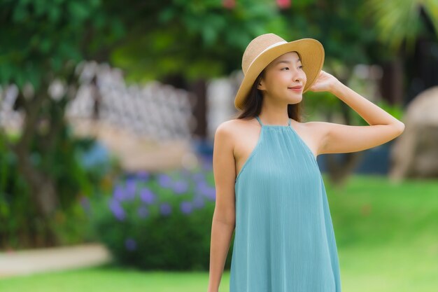 Улыбка красивой азиатской женщины портрета счастливая ослабляет с прогулкой в саде