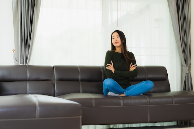 Beautiful portrait young asian woman sit relax on sofa