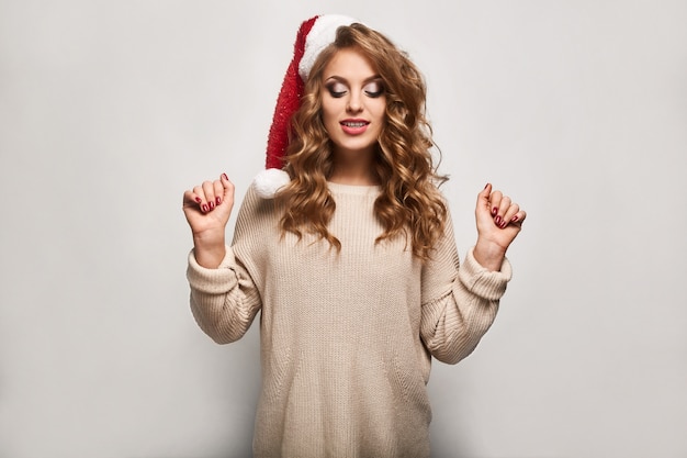 Beautiful positive blonde in a sweater and festive cap