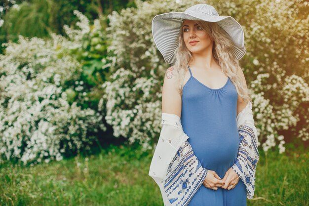 Beautiful pregnancy woman in a summer park