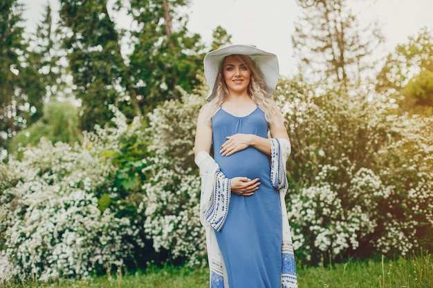 Foto gratuita bella donna di gravidanza in un parco estivo