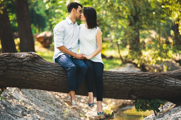 Beautiful pregnant couple relaxing outside in the forest