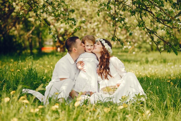 beautiful pregnant girl in a long white dress with her boyfriend and their little daughter