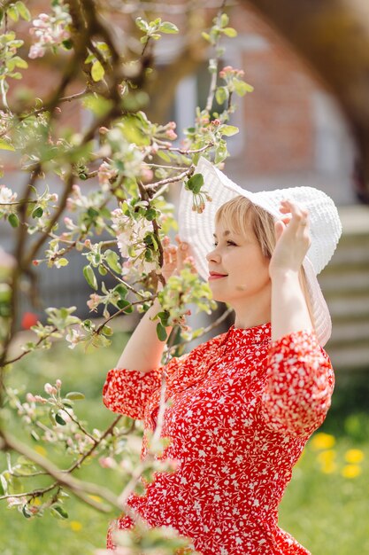 Beautiful pregnant woman relaxing in the park wearing red dress