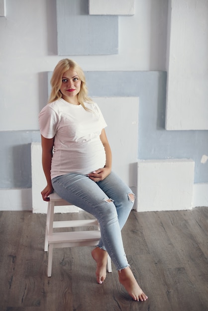Beautiful pregnant woman with big belly in a studio