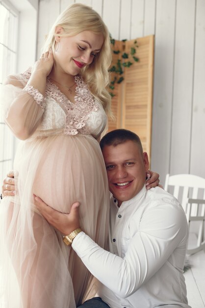 Beautiful pregnant woman with her husband in a studio