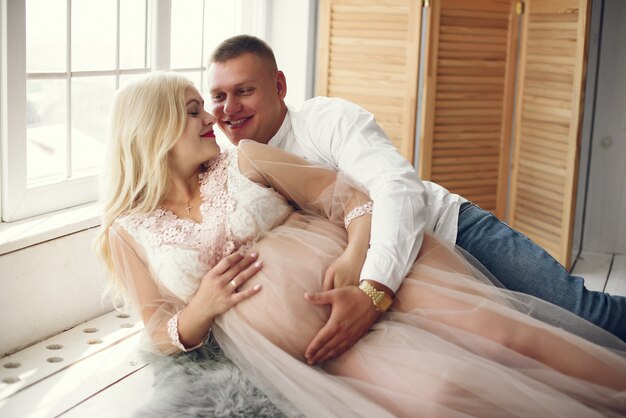 Beautiful pregnant woman with her husband in a studio