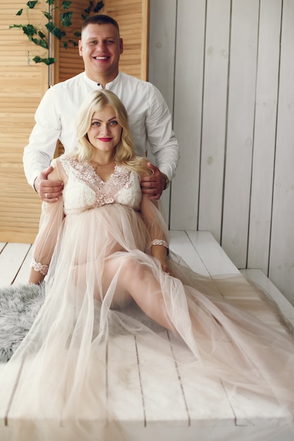 Foto gratuita bella donna incinta con il marito in uno studio