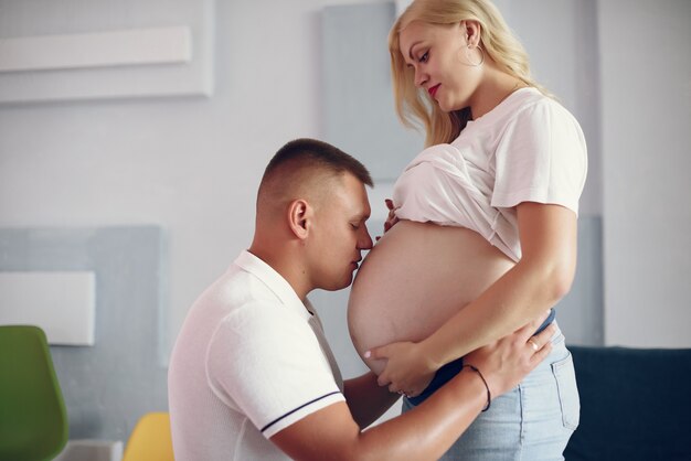 Красивая беременная женщина с мужем в студии