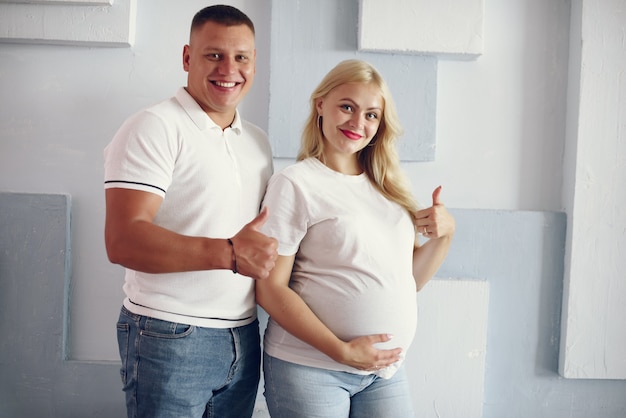 Beautiful pregnant woman with her husband in a studio