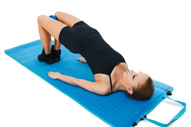 Beautiful red girl exercising with ball and yoga mat