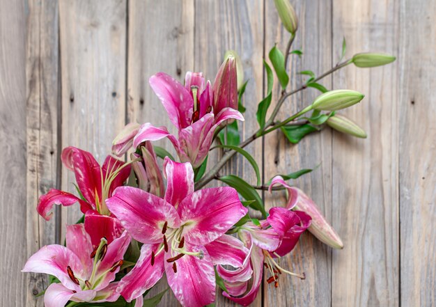 Beautiful, red Lily flowers, scattered on a wooden background, close-up.