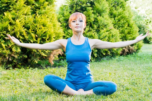 Beautiful red woman doing fitness or yoga exercises