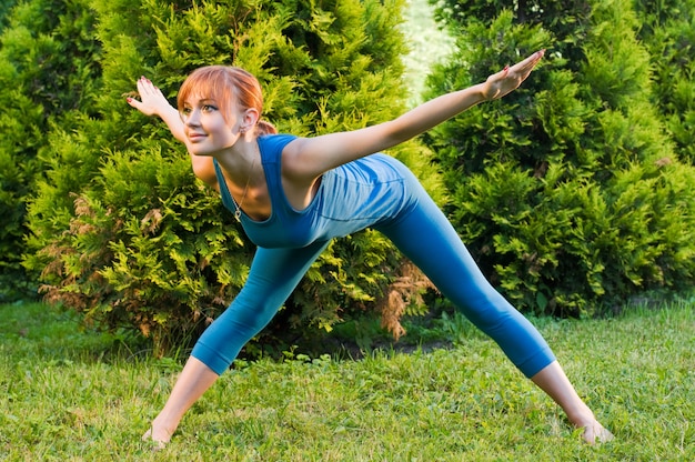 Beautiful red woman doing fitness or yoga exercises