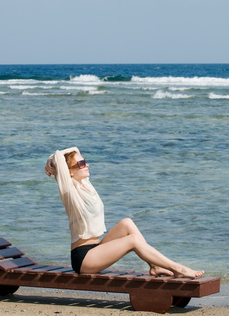 Beautiful red woman relaxing by the ocean