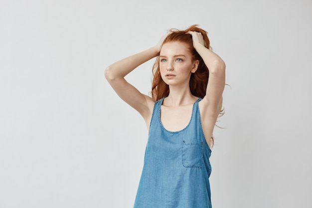 Free photo beautiful redhead model touching hair posing looking to distance.