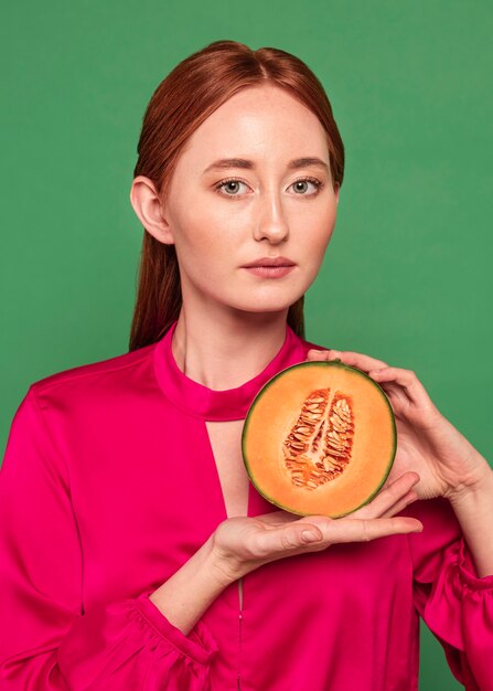 Beautiful redhead woman holding a melon