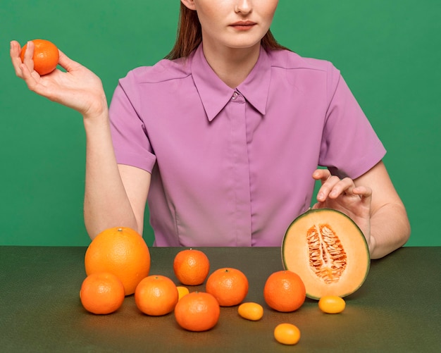 Foto gratuita bella donna della testarossa che posa con i frutti