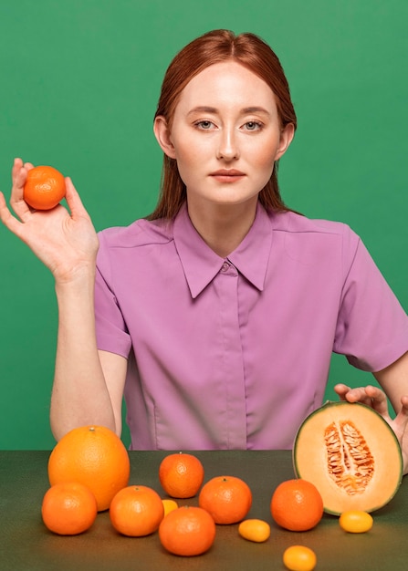 Beautiful redhead woman posing with oranges