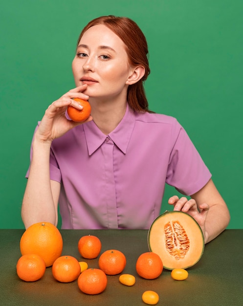 Beautiful redhead woman posing with oranges