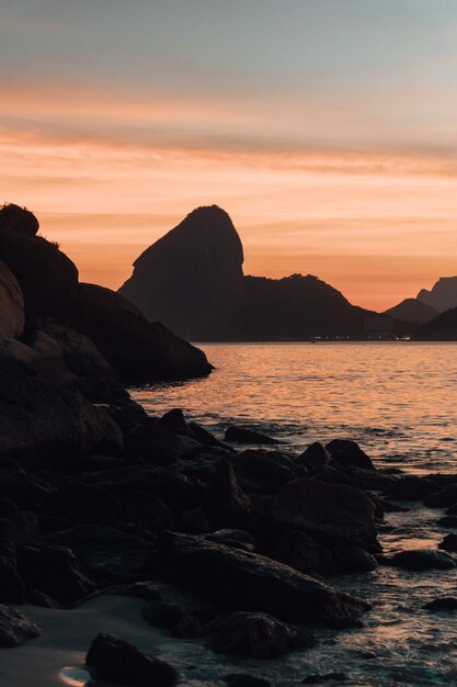 Beautiful rock formations near the sea with the sunset in Rio de Janeiro