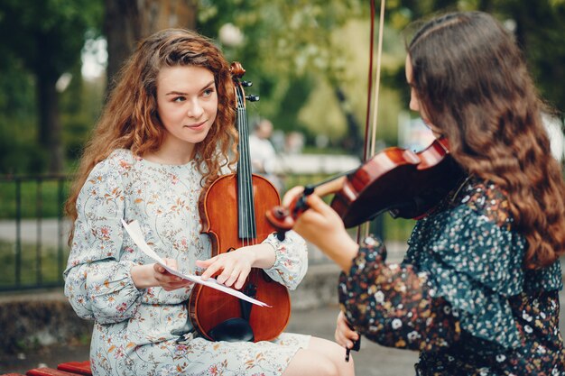 Beautiful and romantic girls in a park with a violin