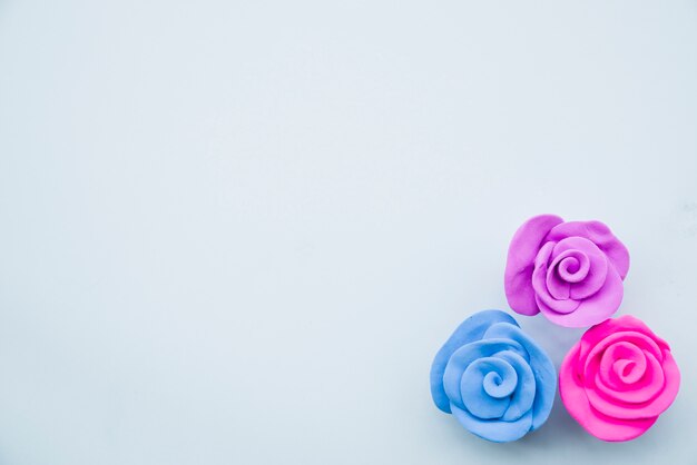 Beautiful roses made with colorful clay on gray backdrop