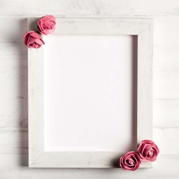 Foto gratuita belle rose su semplice cornice di legno
