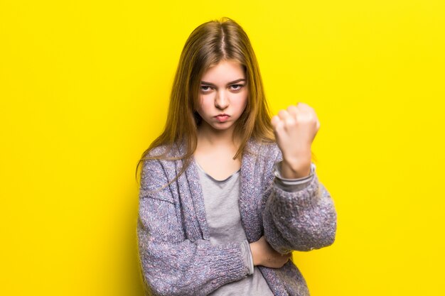 Beautiful sad young teen girl close-up threatens fist