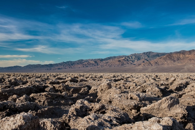 Beautiful scene of a rocky ground in a desert and the bright blue sky in the background