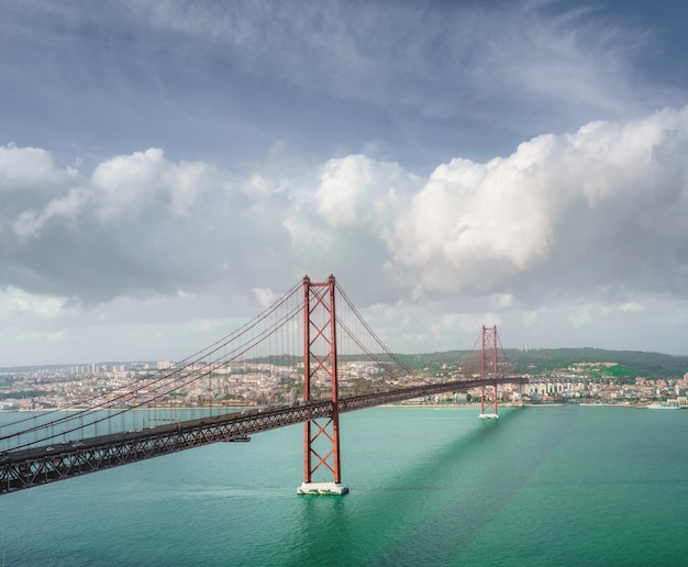 息をのむような雲の形成の下でポルトガルの25 de Abril橋の美しい風景