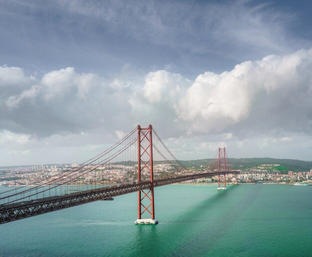 Beautiful scenery of the 25 de Abril bridge in Portugal under the breathtaking cloud formations