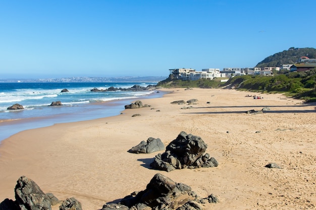 Beautiful scenery of a beach surrounded by hills under the clear sky