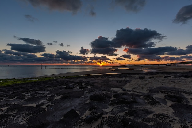Beautiful scenery of a breathtaking sunset over the calm ocean in Westkapelle, Zeeland