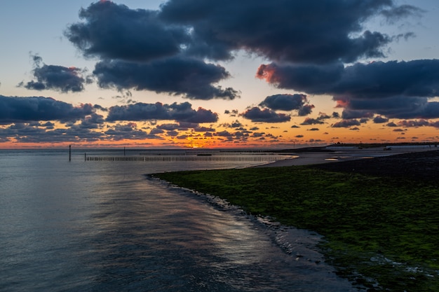 Westkapelle, Zeeland에서 잔잔한 바다 위에 숨이 sunset을듯한 일몰의 아름다운 풍경