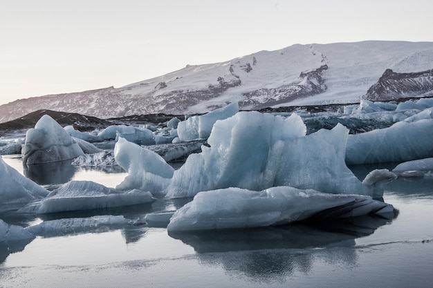Foto gratuita lo splendido scenario della laguna del ghiacciaio jokulsarlon si riflette nel mare in islanda