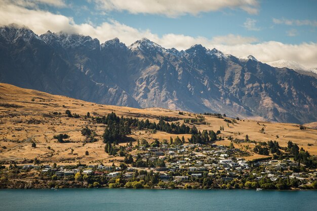 Beautiful scenery of a landscape with a lot of buildings near high rocky mountains by the sea