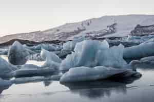 Бесплатное фото Красивый пейзаж лагуны ледника jokulsarlon отражается в море в исландии