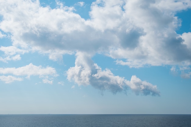 Free photo beautiful scenery of a peaceful sea under the breathtaking white clouds