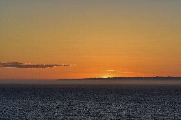 息を呑むような夕日を背景にした穏やかな海の美しい風景