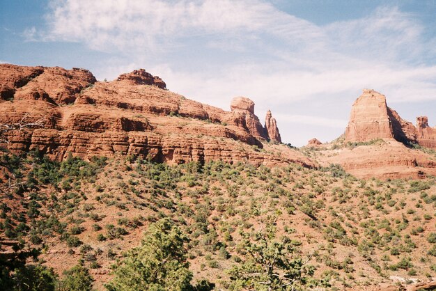 Beautiful scenery of rocky canyons surrounded by bushes under the breathtaking cloudy sky